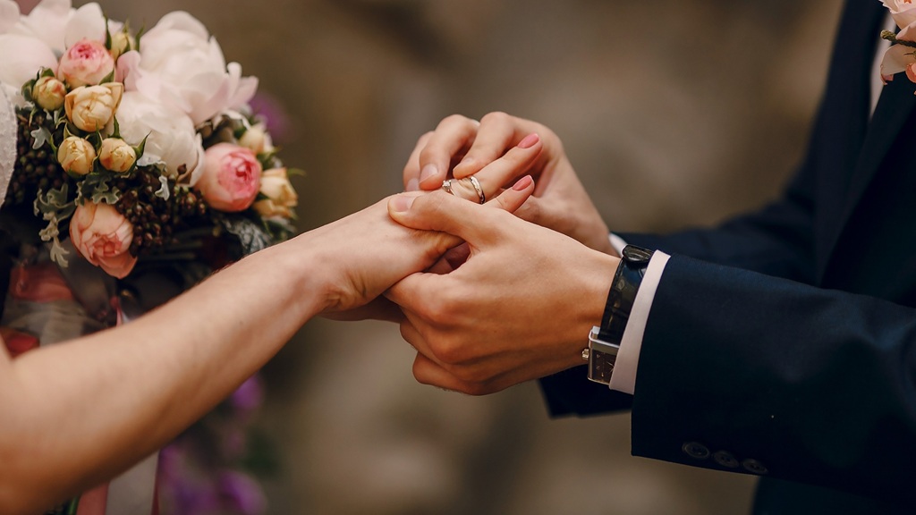 Intieme bruiloft waarbij een bruidspaar elkaar de ring omdoet tijdens een emotionele ceremonie verzorgd door Heliante Moningka